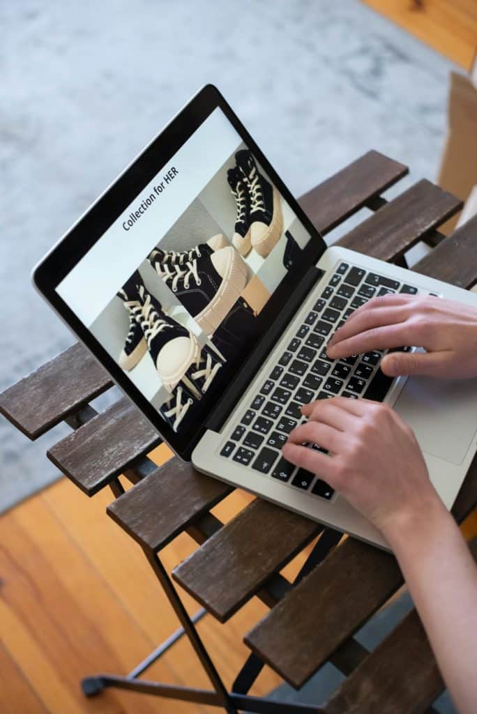 Un ordinateur avec un boutique en ligne et des mains qui tapent sur les touches du clavier